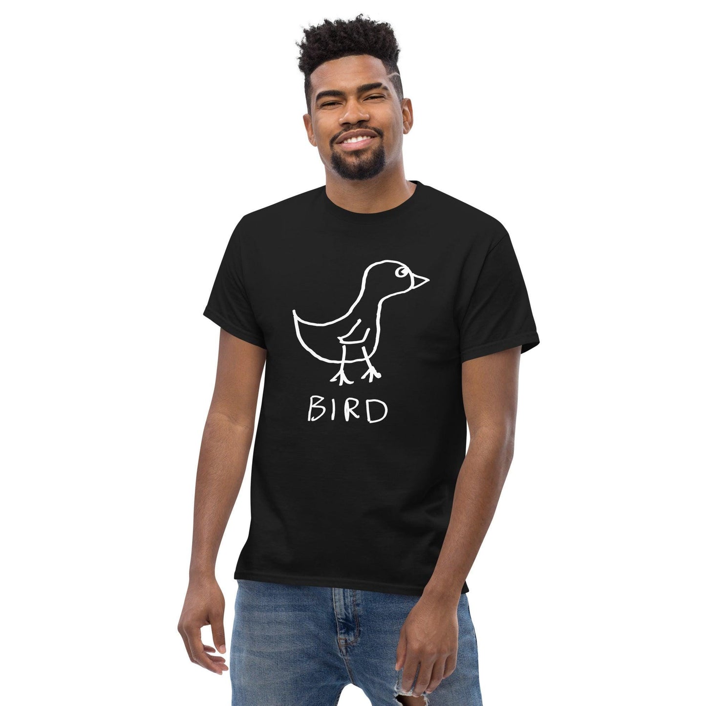 a smiling man wearing jeans and a black t-shirt featuring a crude marker drawing of a bird with the word "Bird" underneath