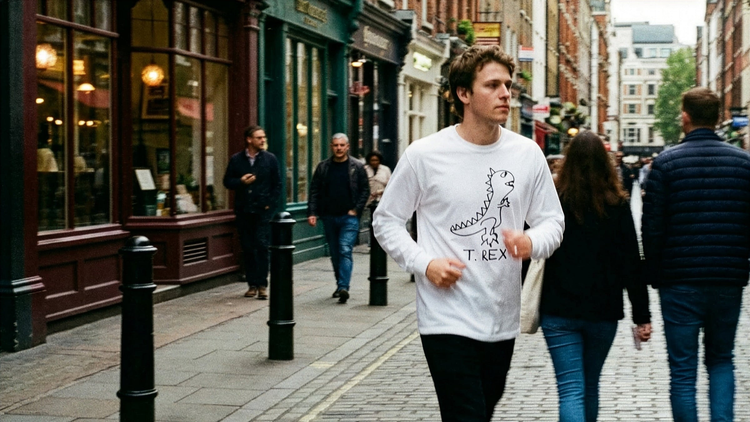 Long Sleeve Tees - LoFi Animal Shirts - Man walks in London wearingwhite long sleeve t-shirt with a hand-drawn T rex graphic