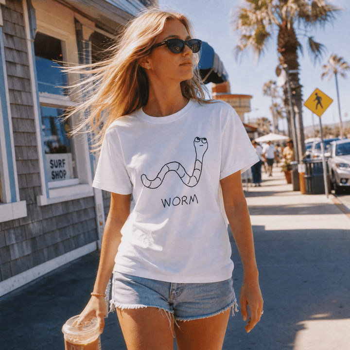 Woman walking a palm-lined beach town street in a lo-fi Worm Women&