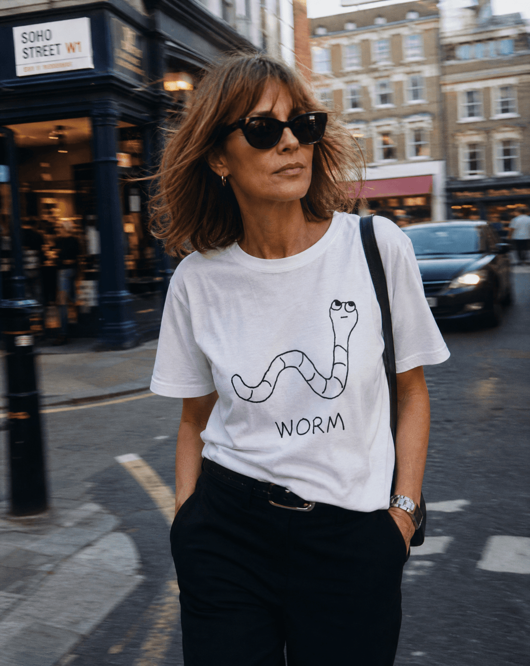 Woman walking a SoHo shopping street in a lo-fi Worm Women&