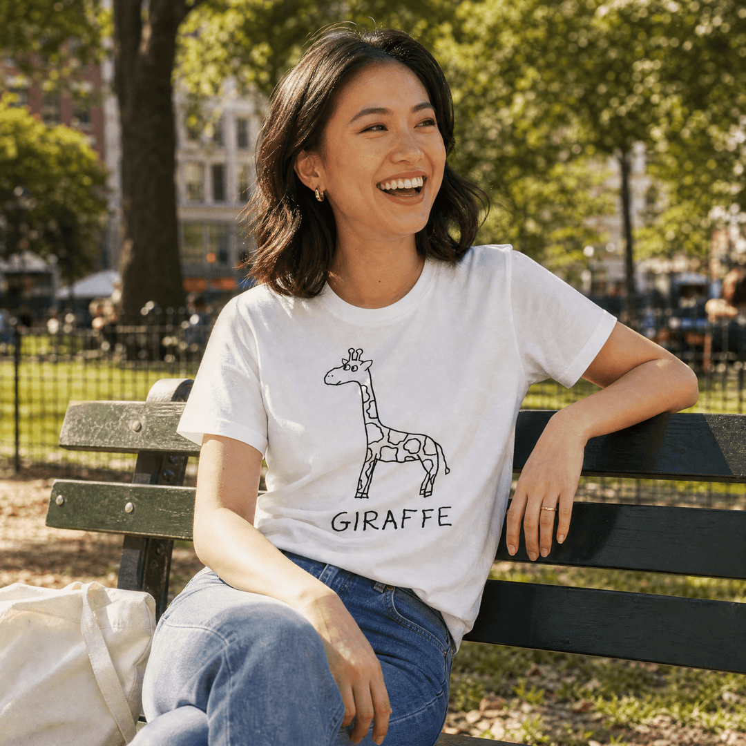 Woman seated on a park bench in a lo-fi Giraffe Women&