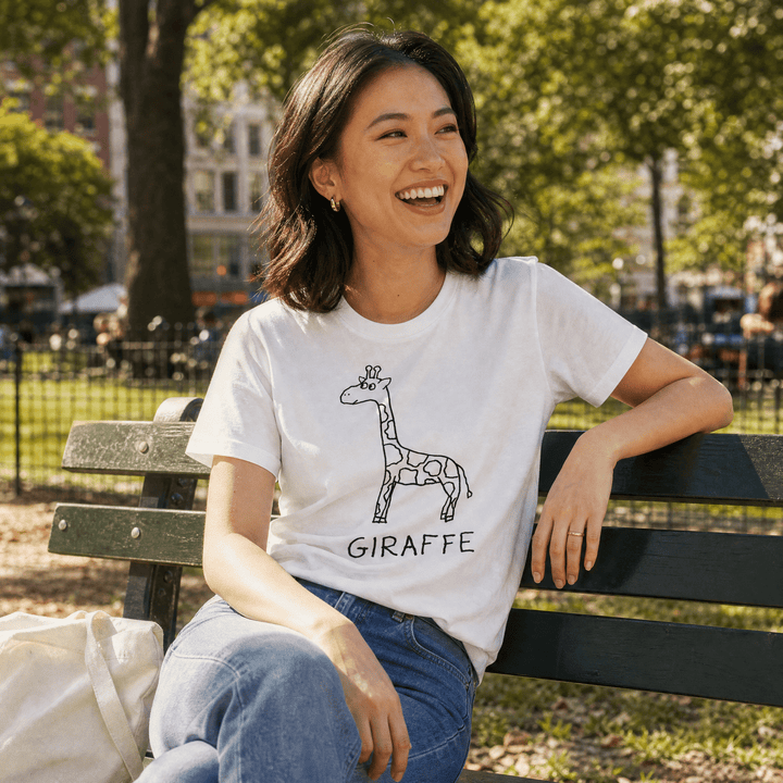 Woman seated on a park bench in a lo-fi Giraffe Women&
