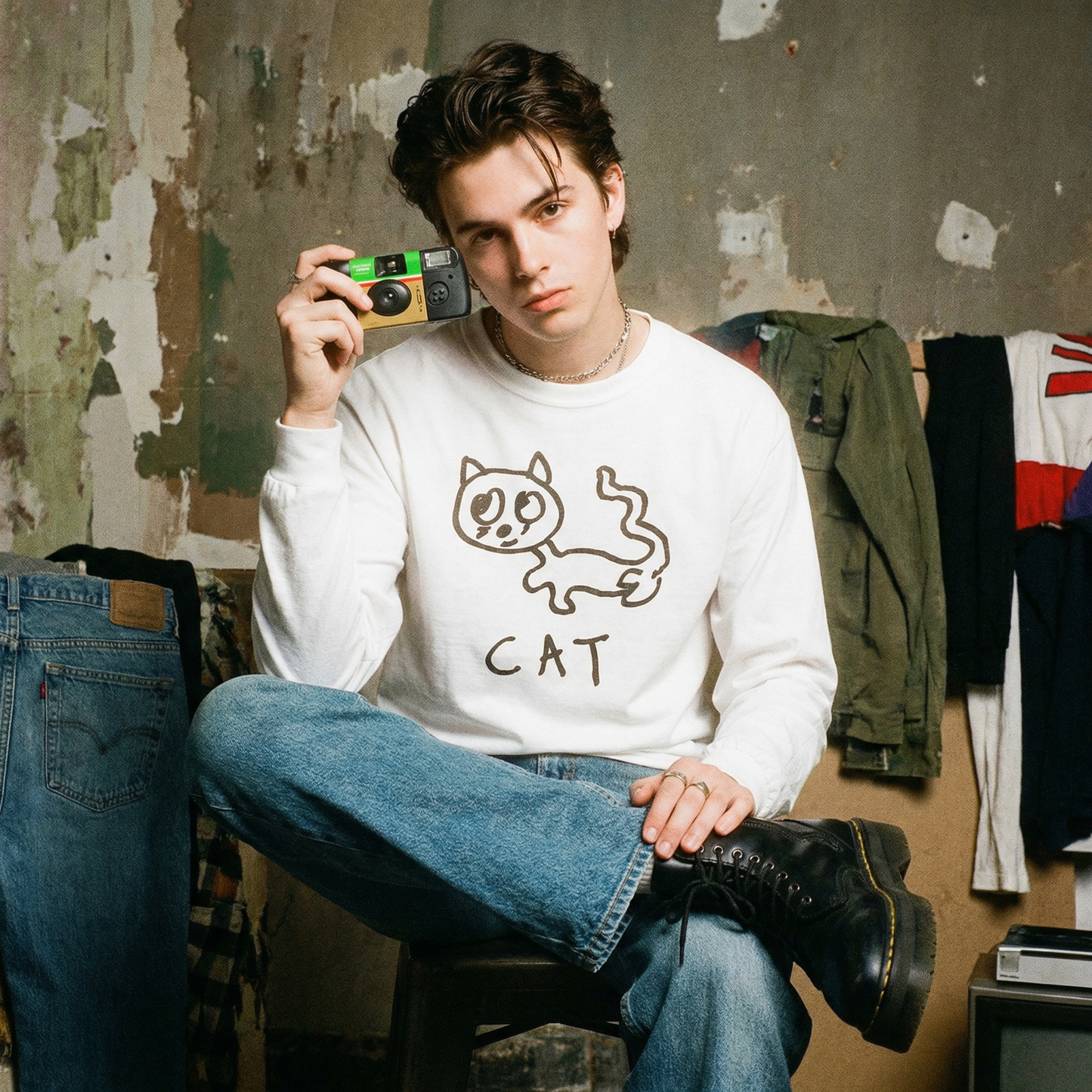 Model wearing a cat graphic long sleeve in a moody, oversized 90s-inspired shoot