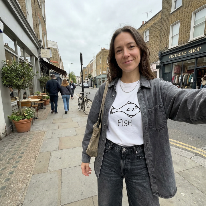 Woman taking a selfie, wearing Fish graphic tee on city street – lofi animal shirt streetwear style