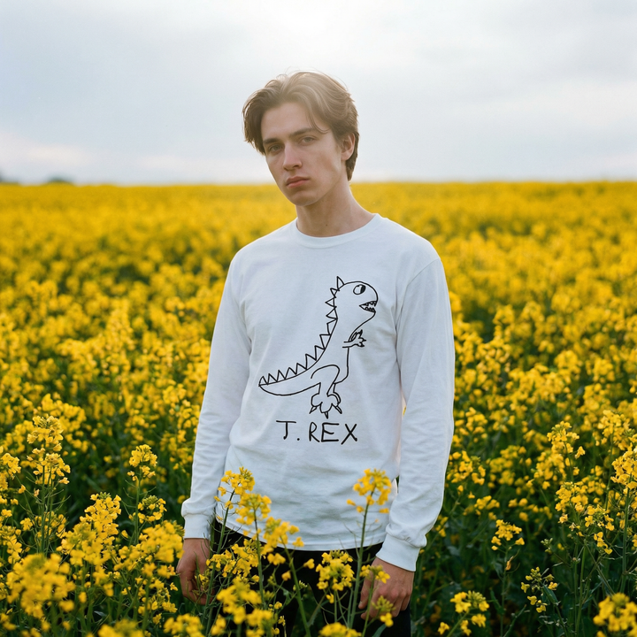 Model in a T-Rex long sleeve tee standing in a field of yellow flowers, arms wide