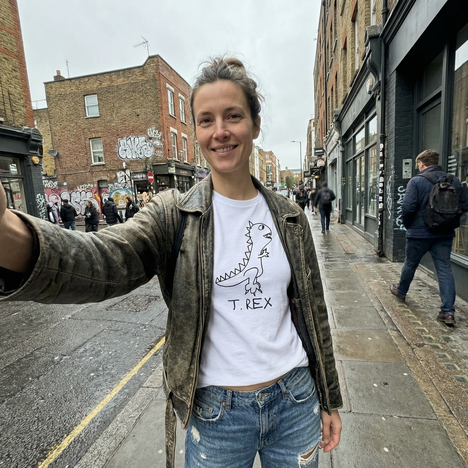 Woman taking a selfie wearing a T-Rex graphic fitted tee on city street – lofi dinosaur shirt style