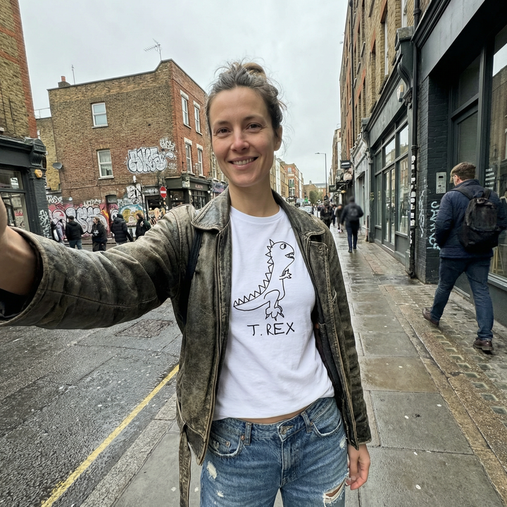 Woman taking a selfie wearing a T-Rex graphic fitted tee on city street – lofi dinosaur shirt style
