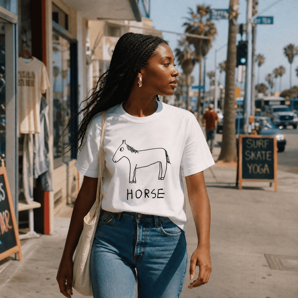 Woman walking a palm-lined beach town street in a lo-fi Horse Women's Relaxed T-Shirt in white