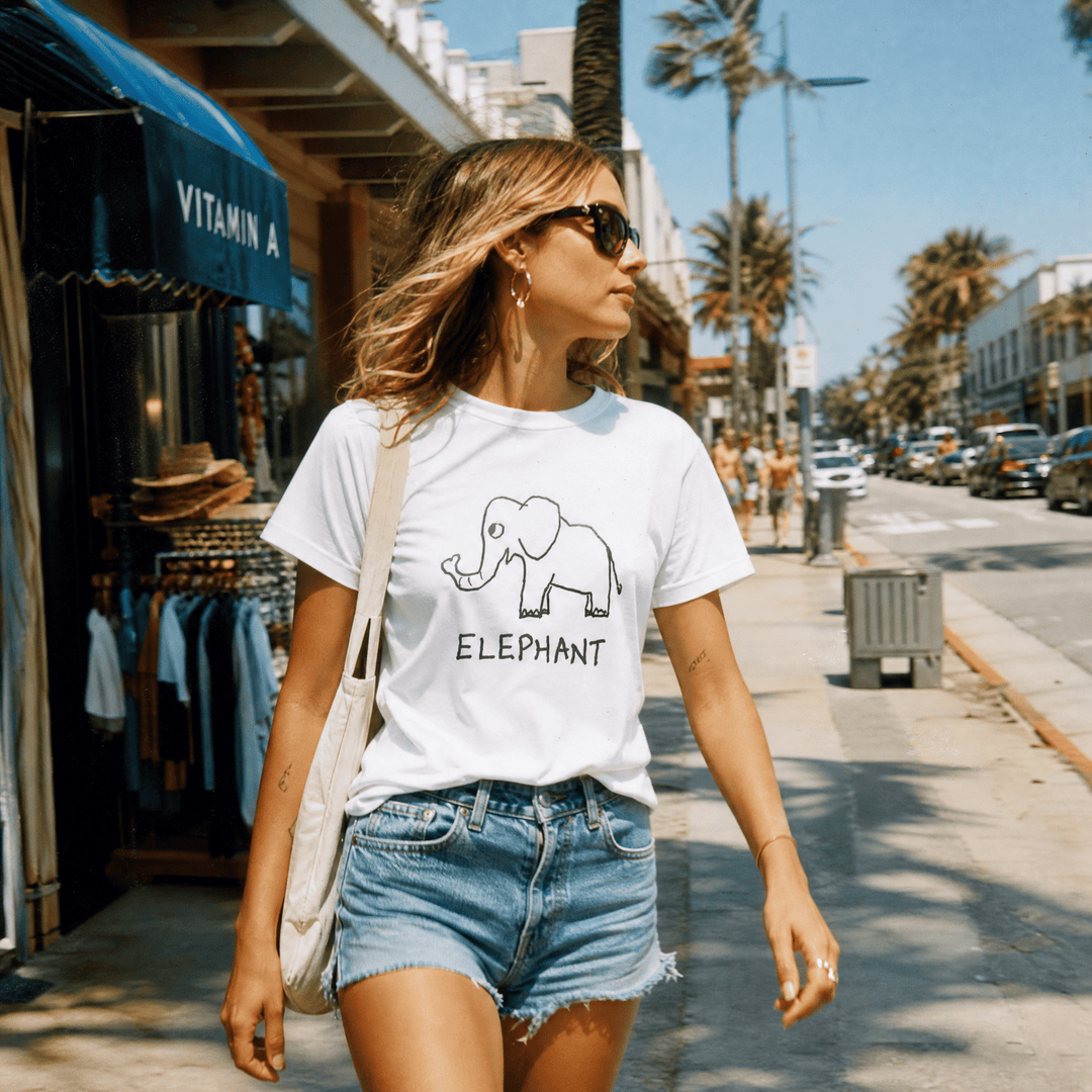 Woman walking a sunny beach town street with palms wearing a lo-fi Elephant Women&