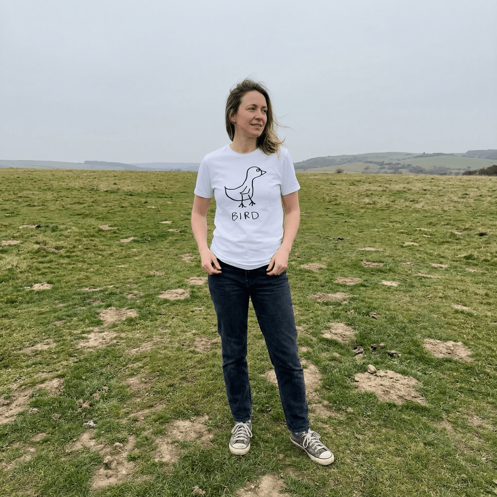 Woman standing in a field wearing a lo-fi Bird Classic Tee