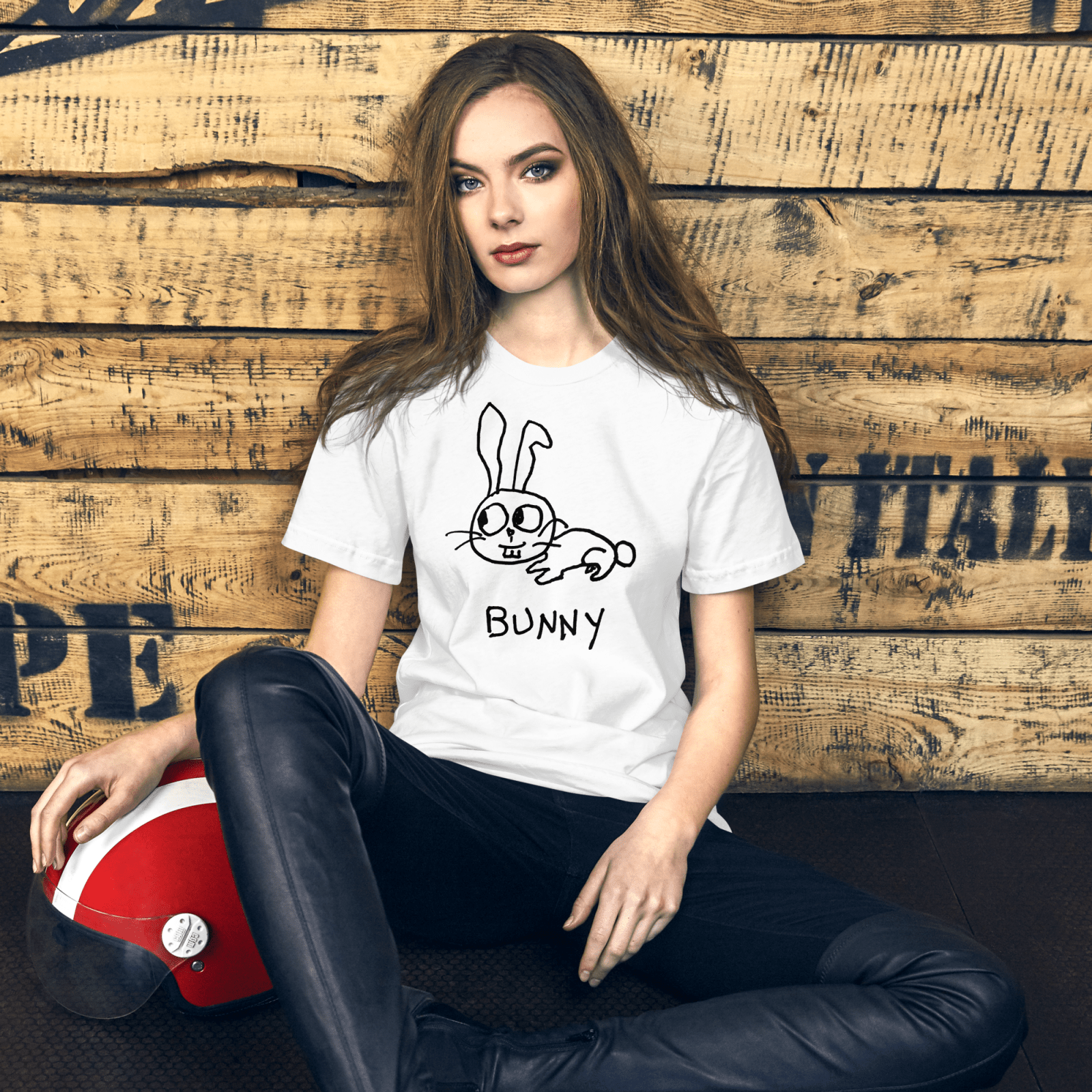 Woman seated against a rustic wood wall wearing a lo-fi Bunny Classic Tee