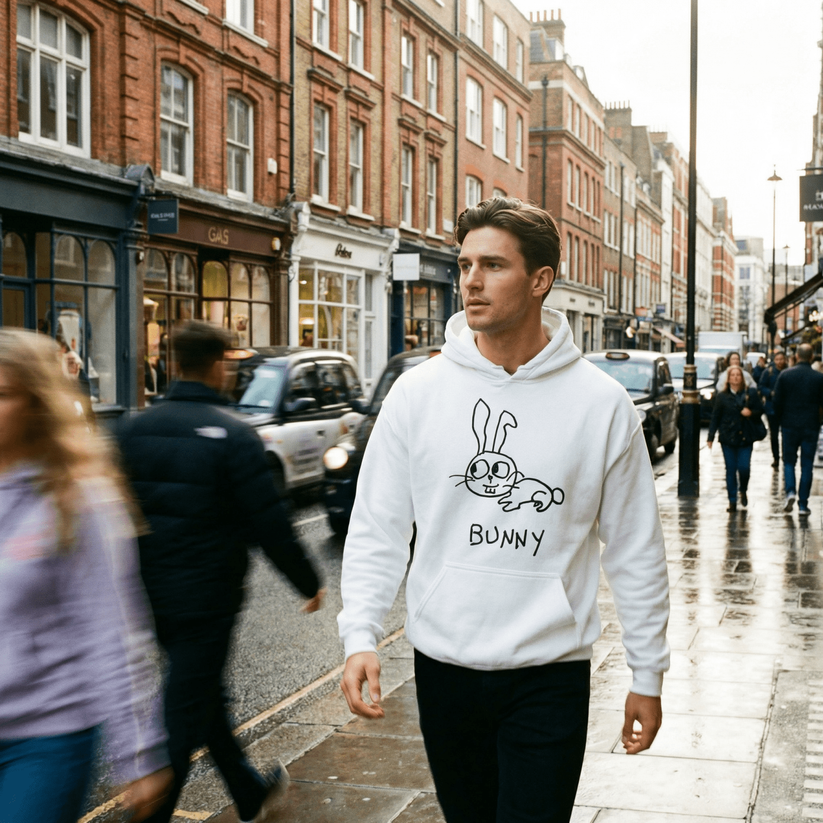 Man walking a rainy London street wearing a lo-fi Bunny Hoodie