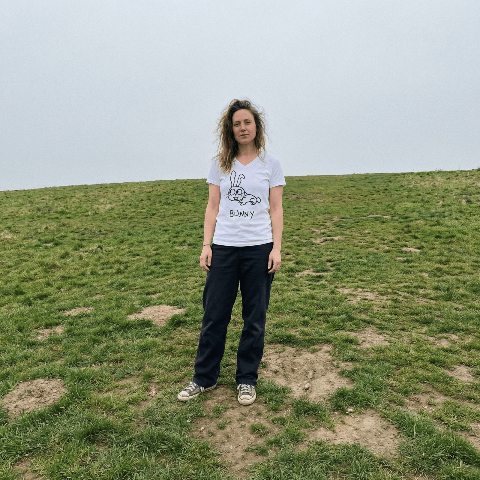 Woman standing on a grassy hill wearing a lo-fi Bunny V-Neck T-Shirt