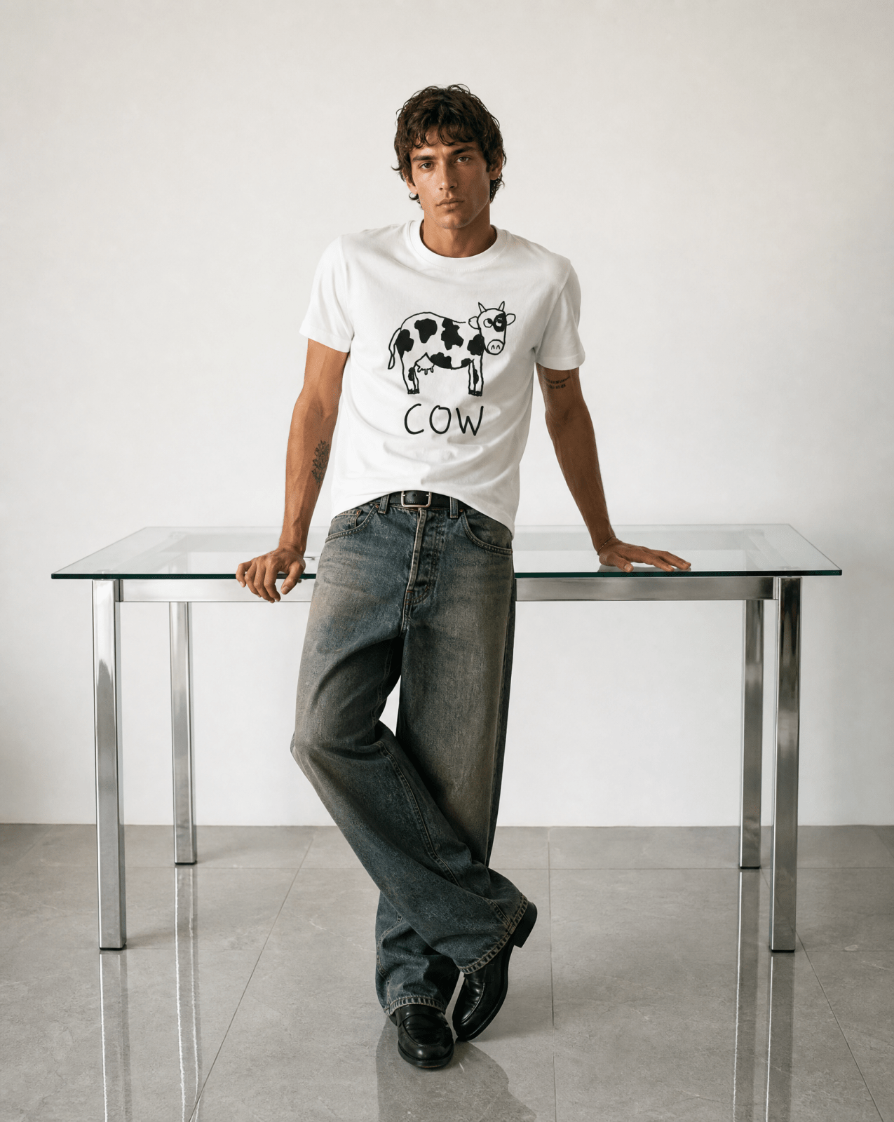Man leaning on a studio table wearing a lo-fi Cow Classic Tee