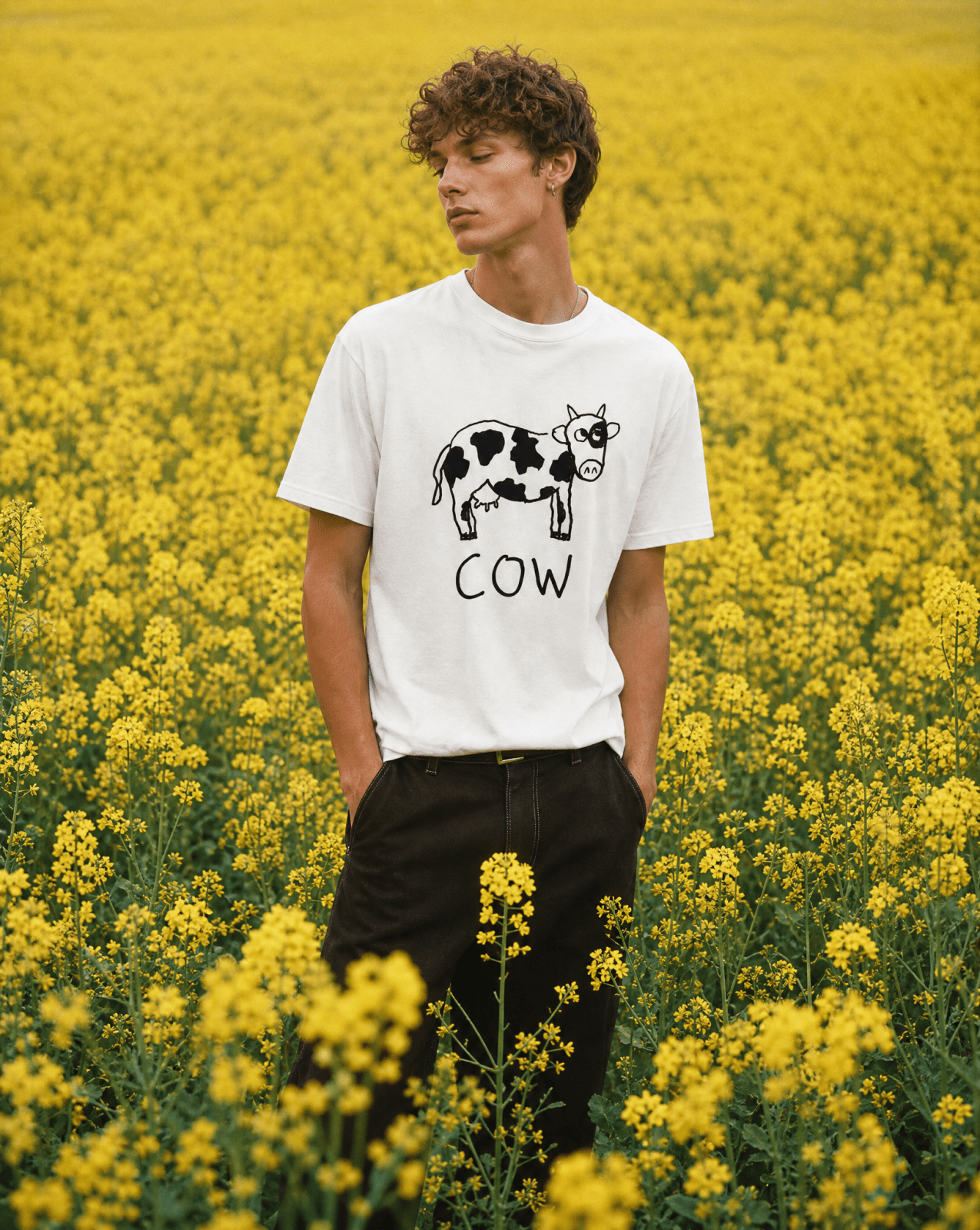 Man in a yellow flower field wearing a lo-fi Cow Classic Tee