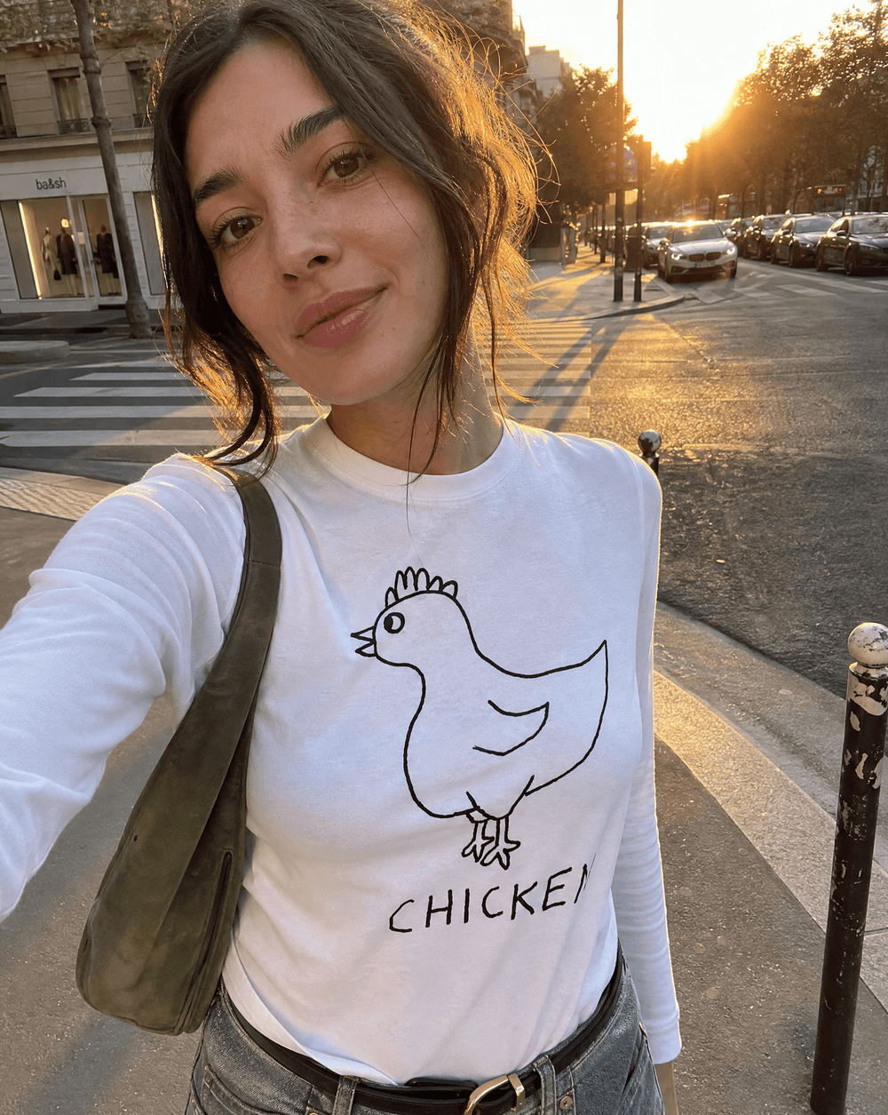 Woman taking a street selfie in a lo-fi Chicken Long Sleeve Tee in white