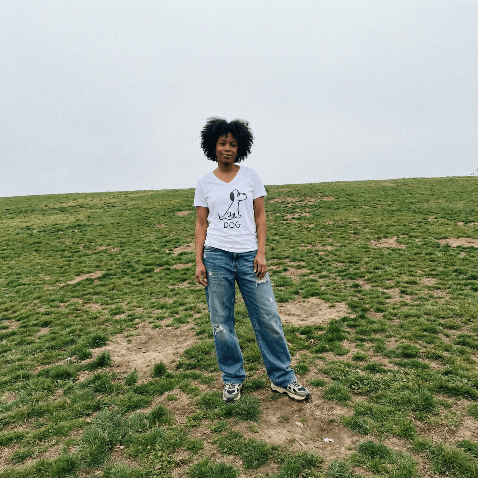 Woman standing on a grassy field wearing a lo-fi Dog V-Neck Tee