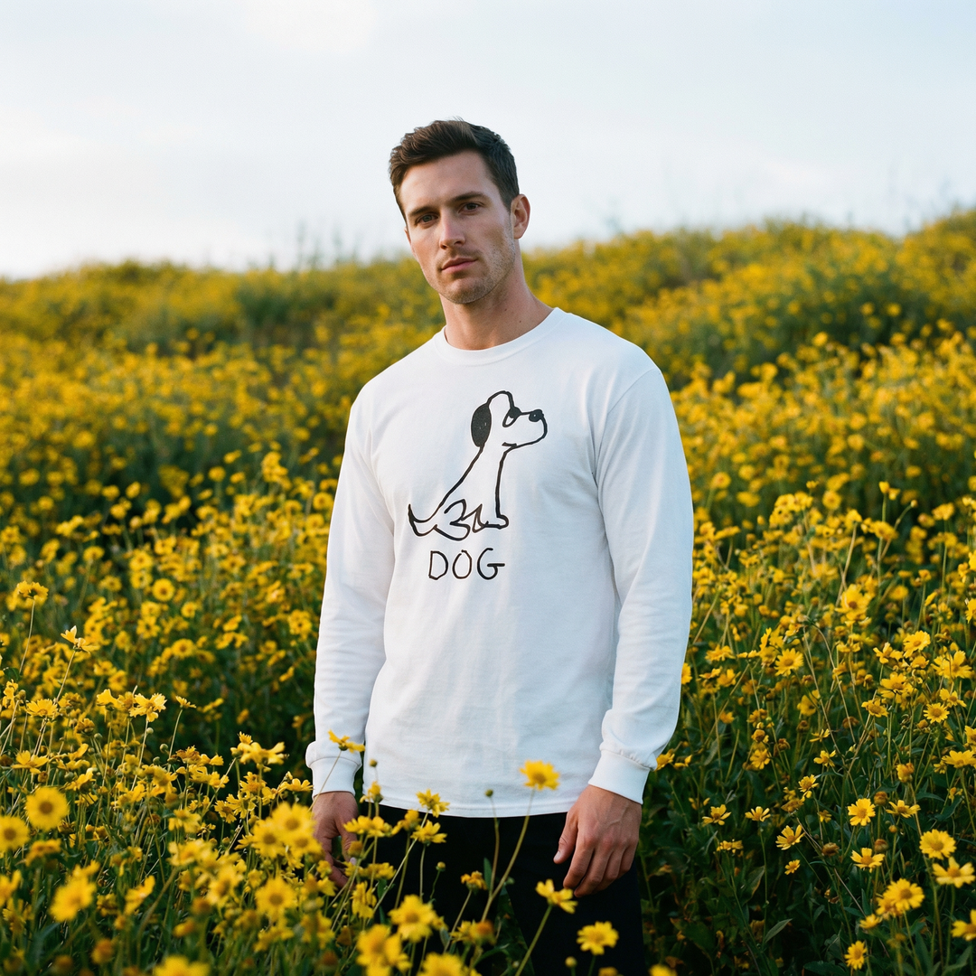 Model in a dog long sleeve tee smiling in a sunlit field of yellow wildflowers