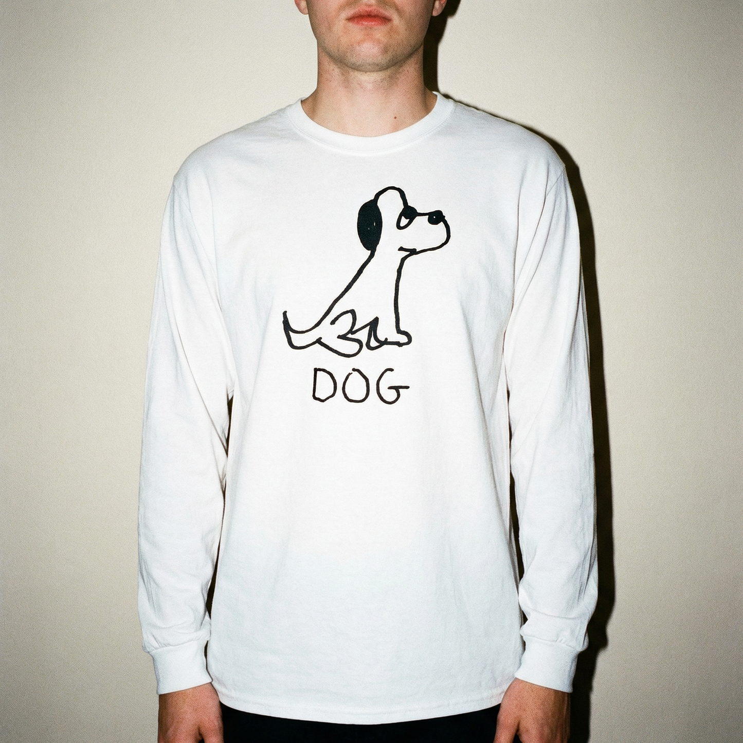 Model wearing a dog long sleeve tee in a bright minimal studio setting