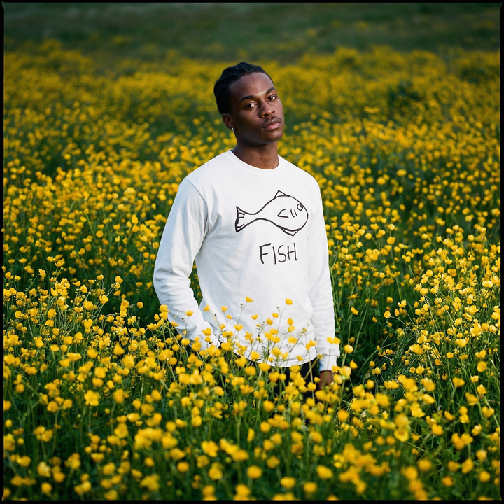 Model in a fish long sleeve tee drifting through a meadow of yellow flowers