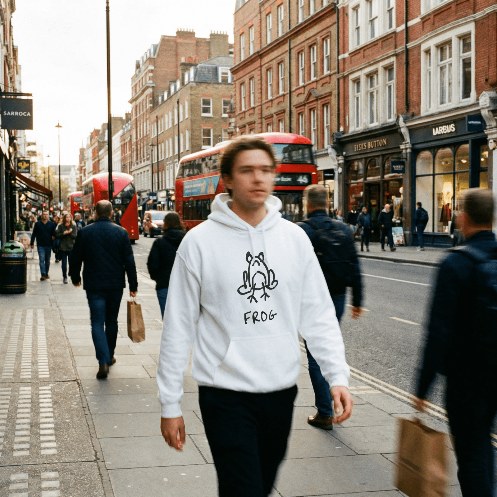 Man walking a London street with a red double-decker bus in the background wearing a lo-fi Frog Hoodie