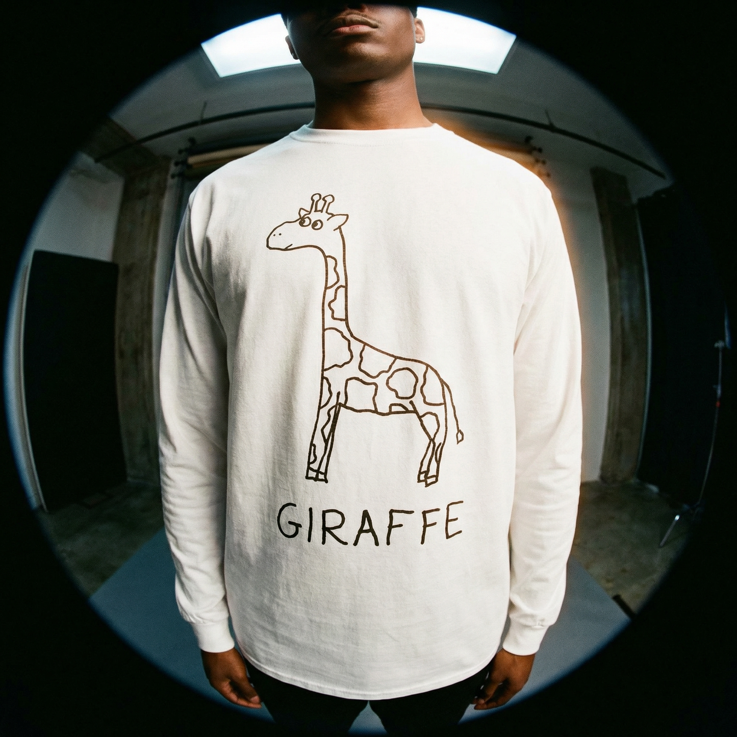 Person wearing a white long-sleeve shirt with a hand drawn giraffe design and the word 'GIRAFFE' on it. Fish eye lens shot.