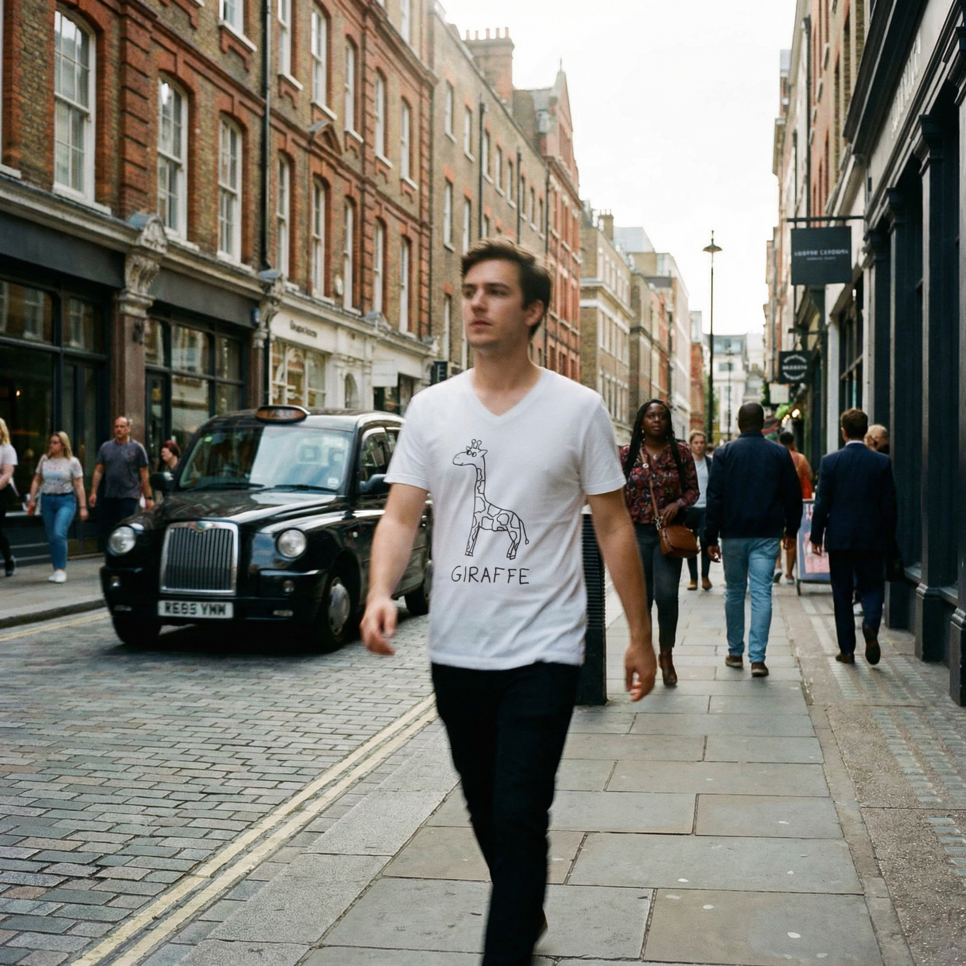 Tall model in a lofi giraffe graphic tee striding through a narrow Soho alley in London