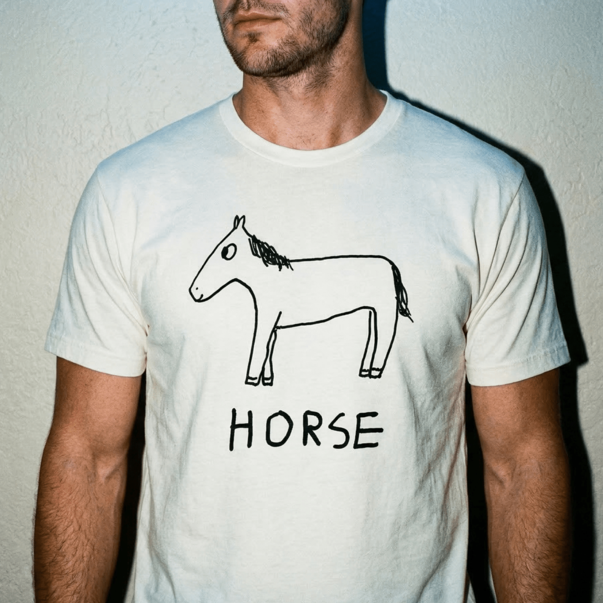 Man in Kodak-film-frame close crop on a plaster wall wearing a lo-fi Horse Classic Tee