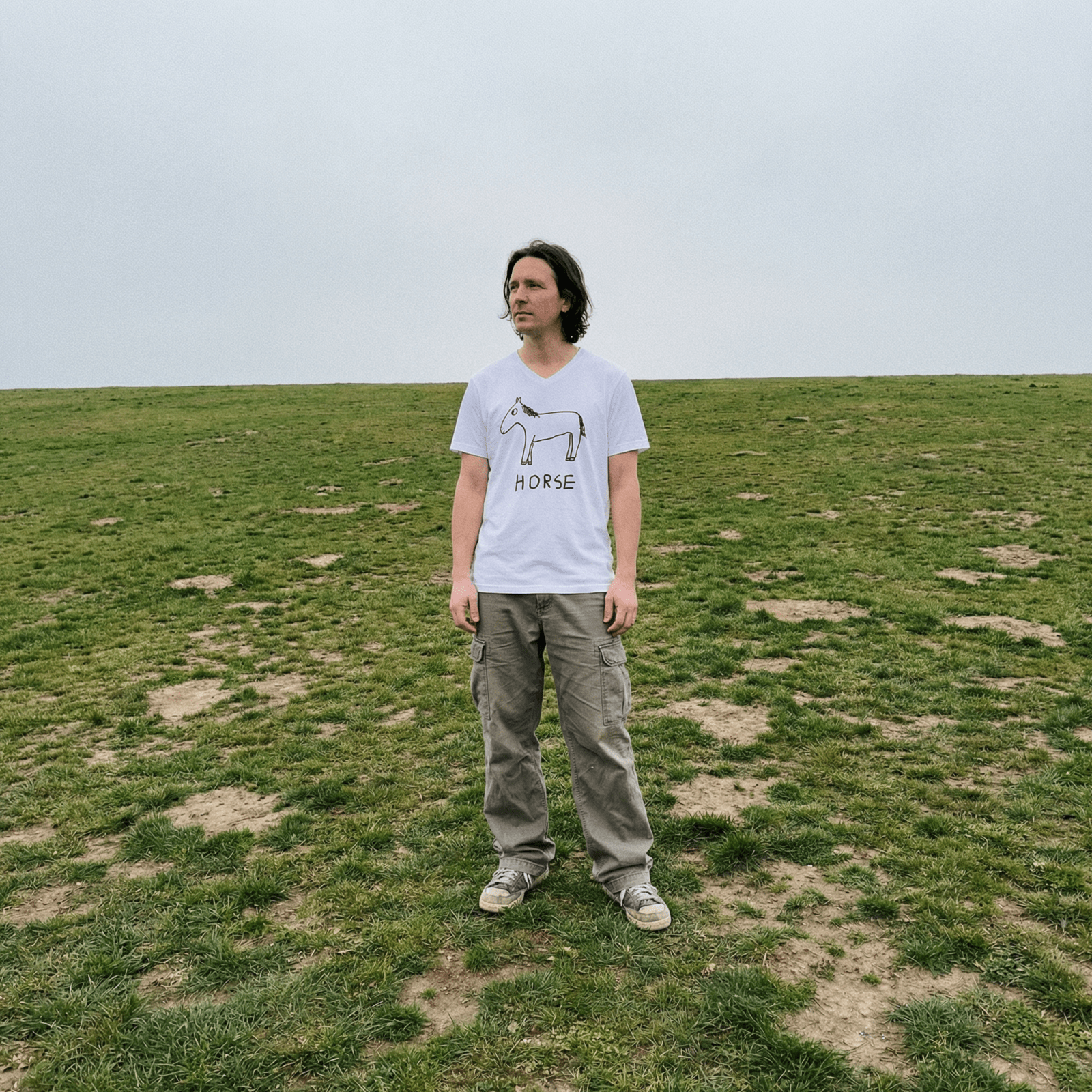 Man in cargo pants in an open field wearing a lo-fi Horse V-Neck Tee
