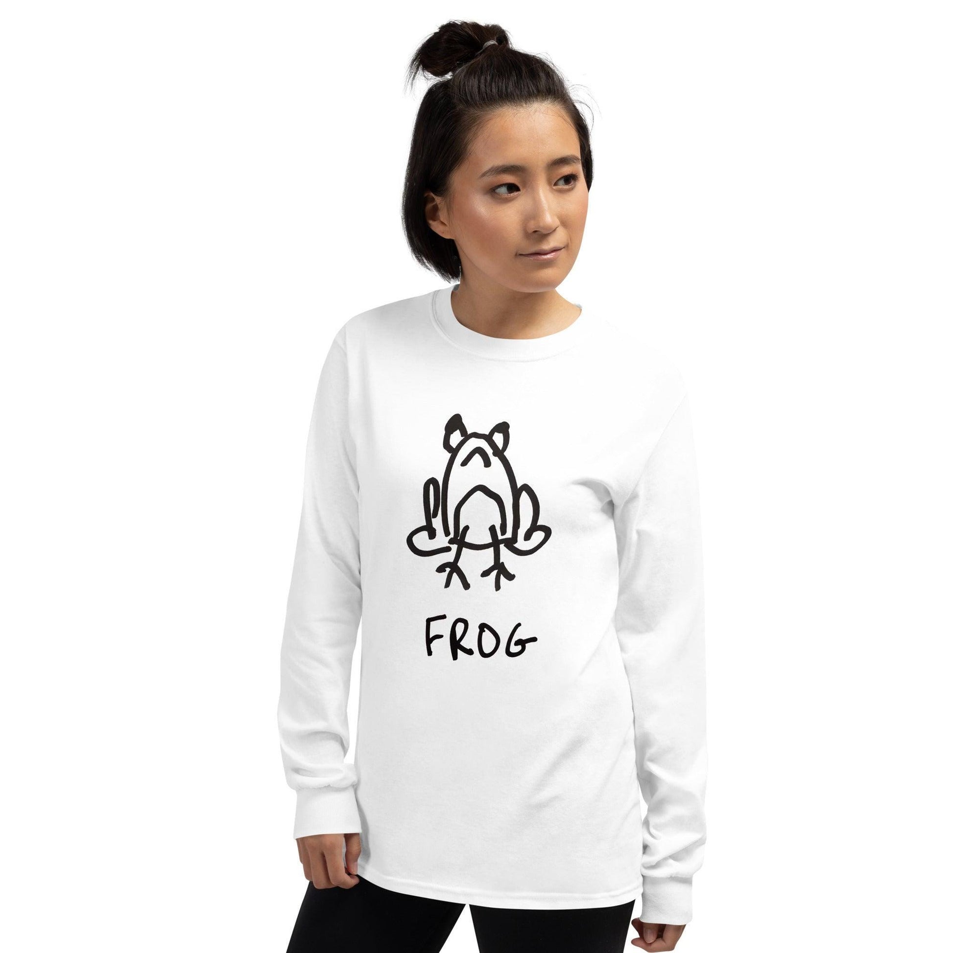 Hip woman on a white background wearing a white long sleeved tee shirt featuring a crude but cute black and white marker marker drawing of a cute frog with the word “FROG” handwritten underneath
