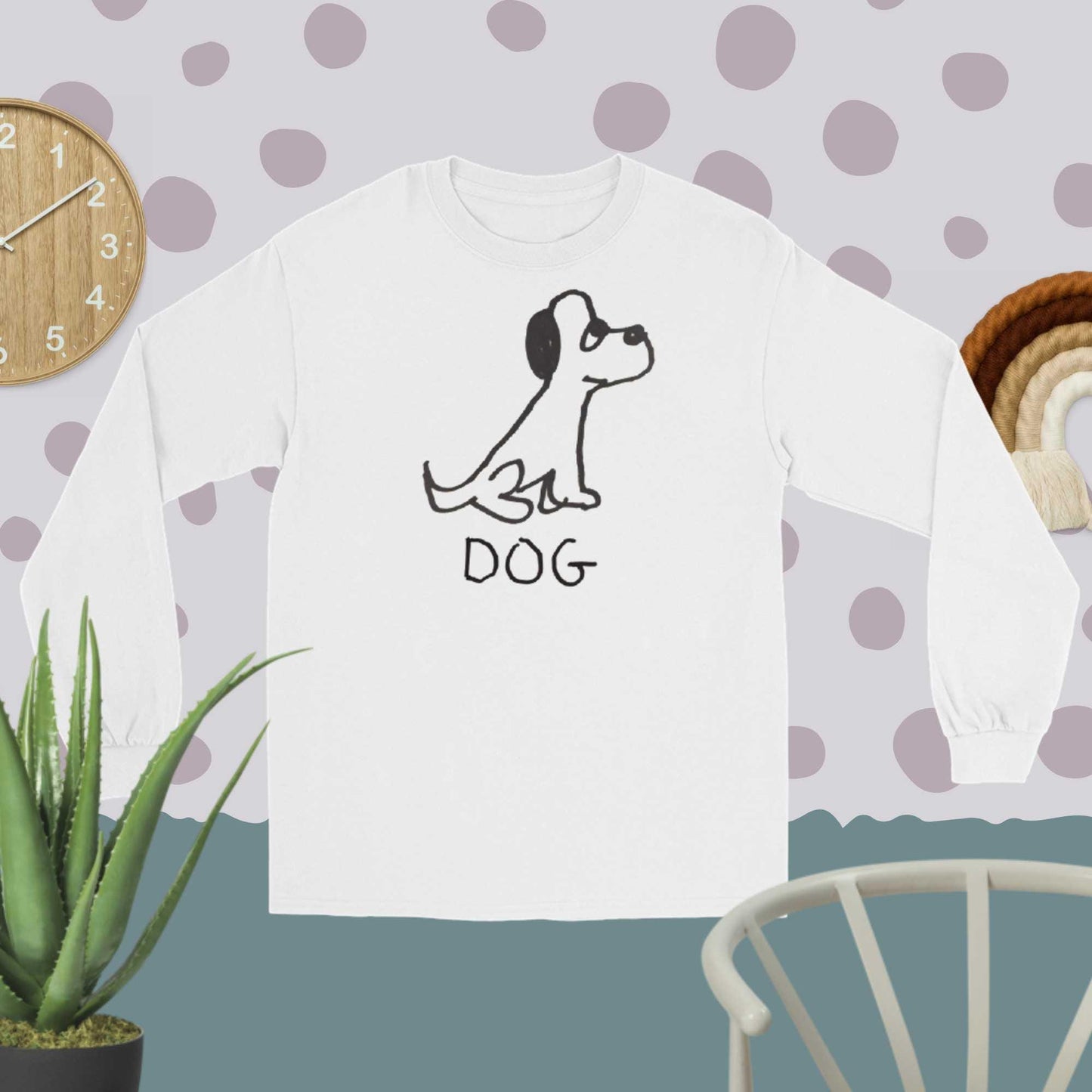 White Long sleeve tee featuring a crude marker black and white marker drawing of a cute dog with the word "DOG" handwritten underneath on a polka dot background. 