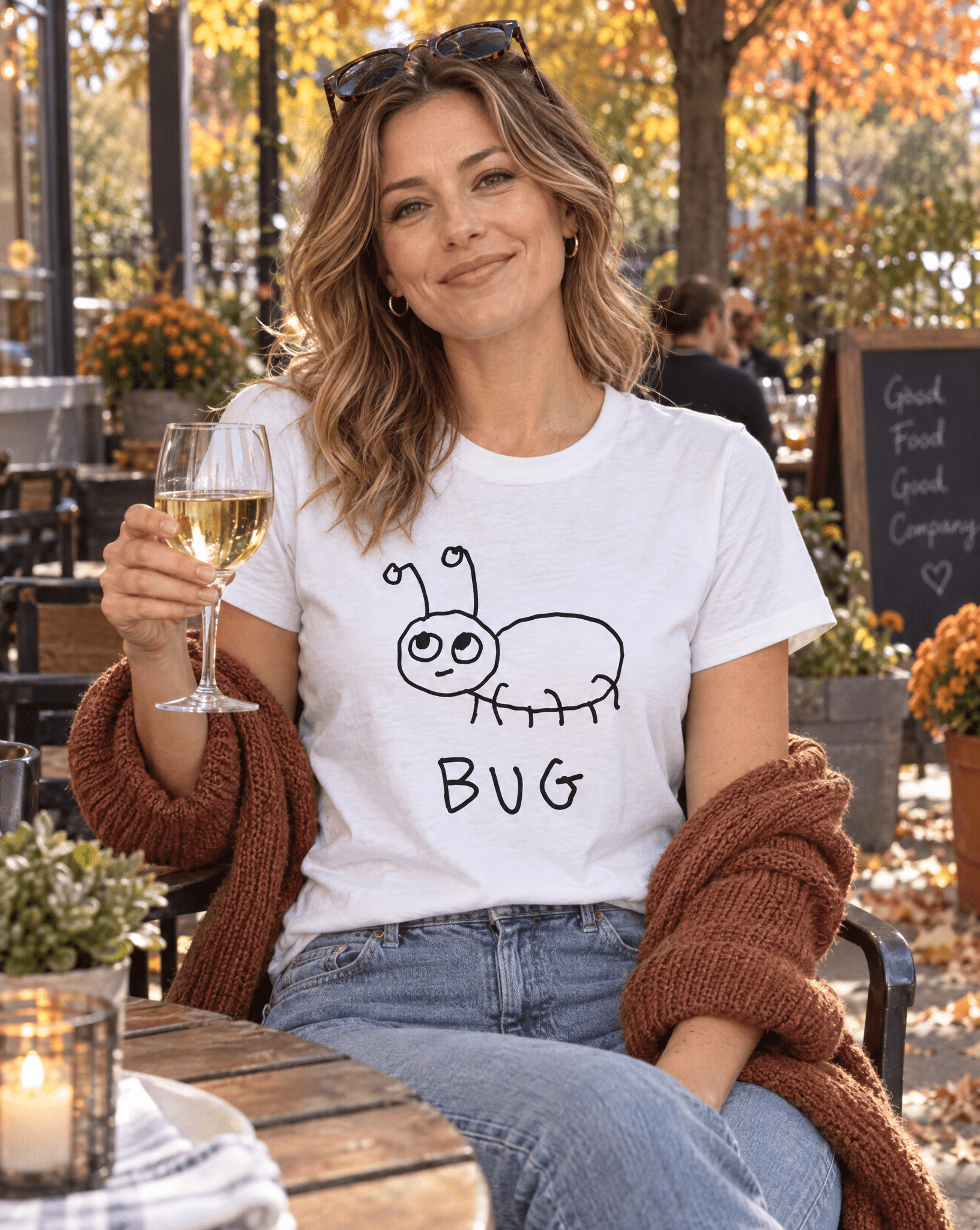 Sep 29 bug women's tee — autumn patio lifestyle photo