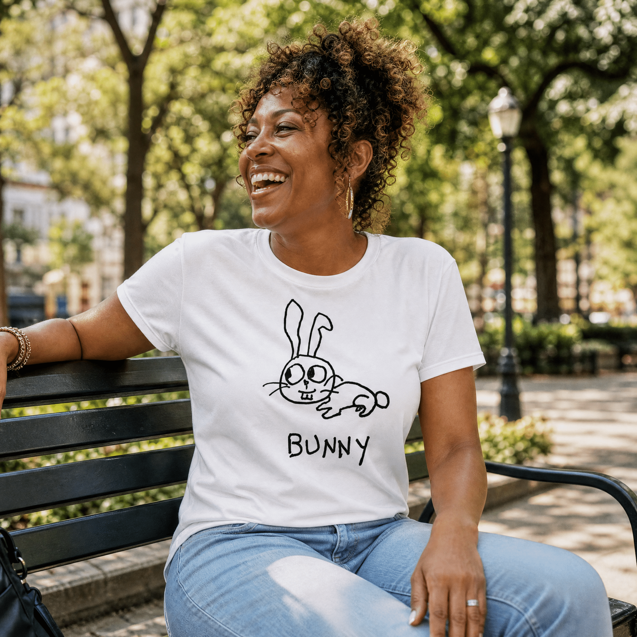 Woman seated on a park bench in a lo-fi Bunny Women's Relaxed T-Shirt in white