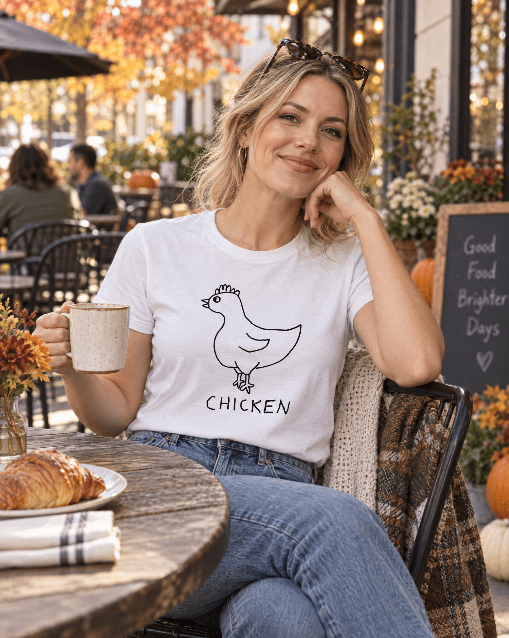 Sep 29 chicken women's tee — autumn patio lifestyle photo