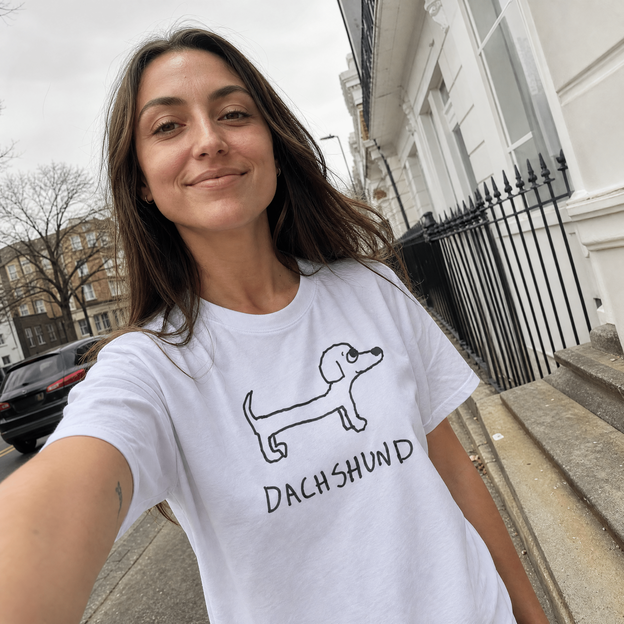 Woman taking a street selfie in a lo-fi Dachshund Women's Relaxed T-Shirt in white