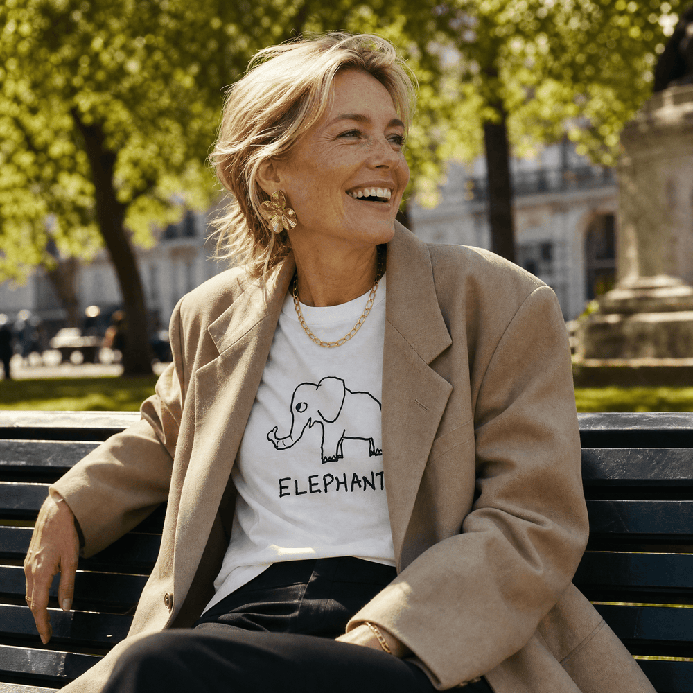 Woman in a park wearing a blazer over a lo-fi Elephant Women's Relaxed T-Shirt in white