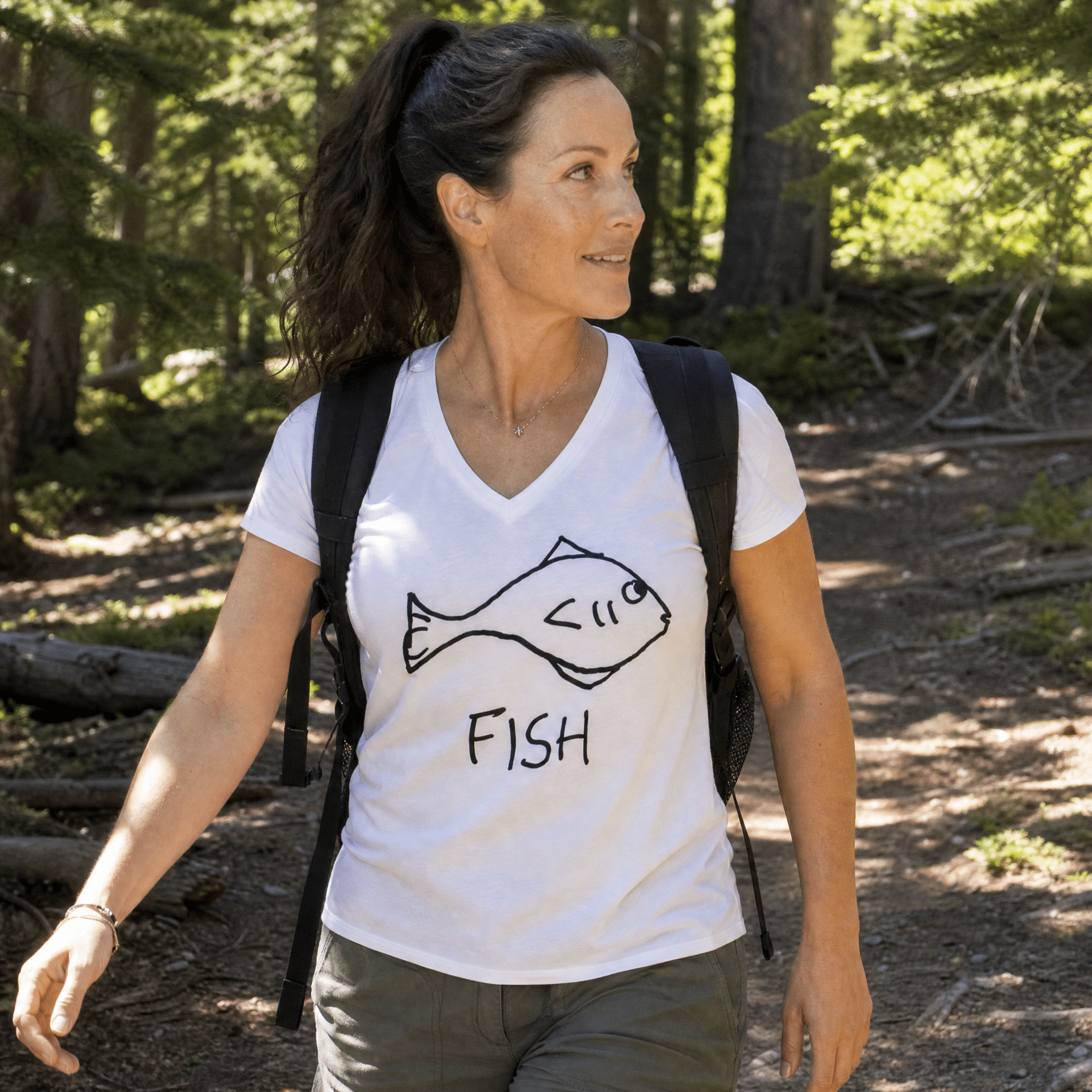 Woman hiking a sunny forest trail wearing a lo-fi Fish Women's V-Neck Tee