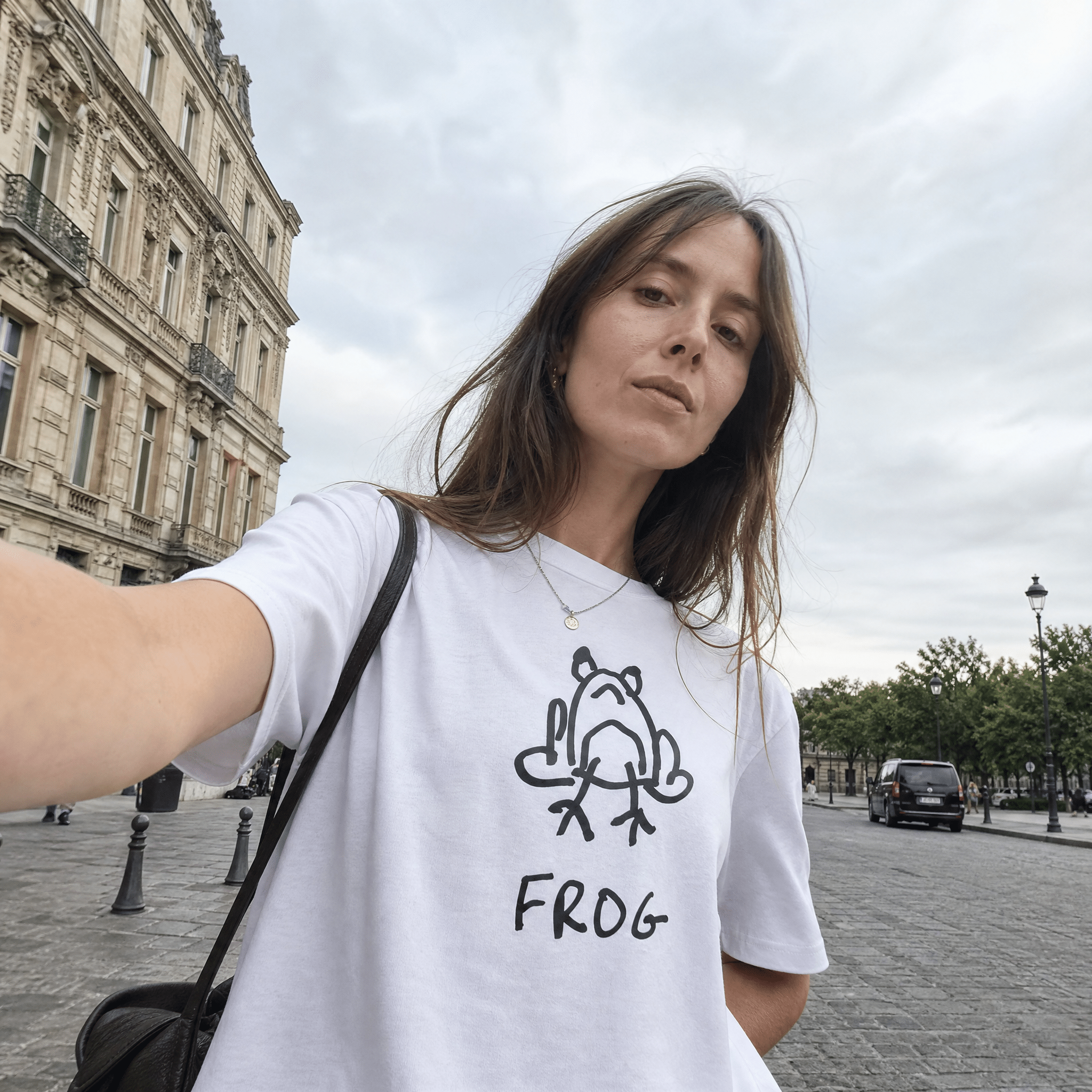 Woman taking a selfie on a European street wearing a lo-fi Frog Women's Relaxed Tee