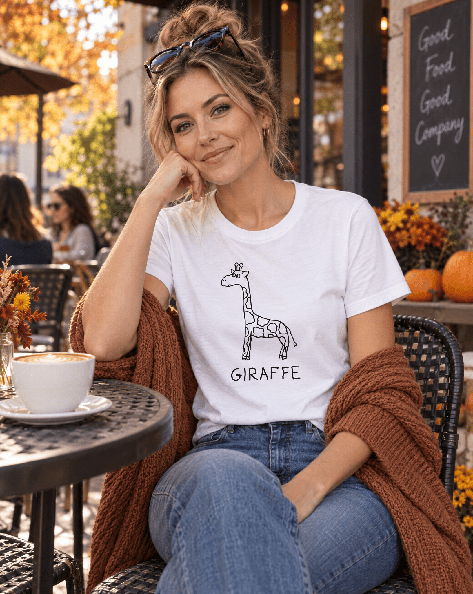 Sep 29 giraffe women's tee — autumn patio lifestyle photo