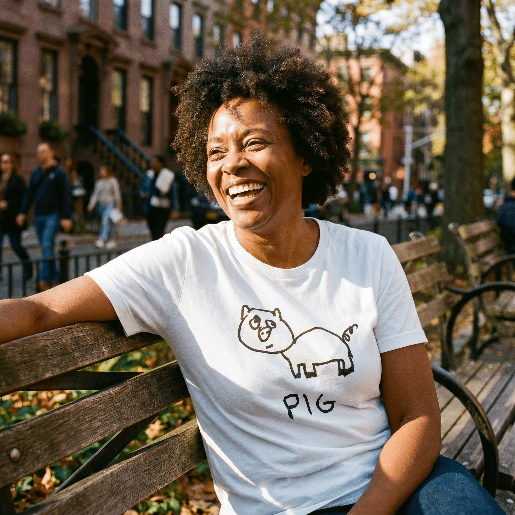 Woman seated on a park bench in a lo-fi Pig Women's Relaxed T-Shirt in white