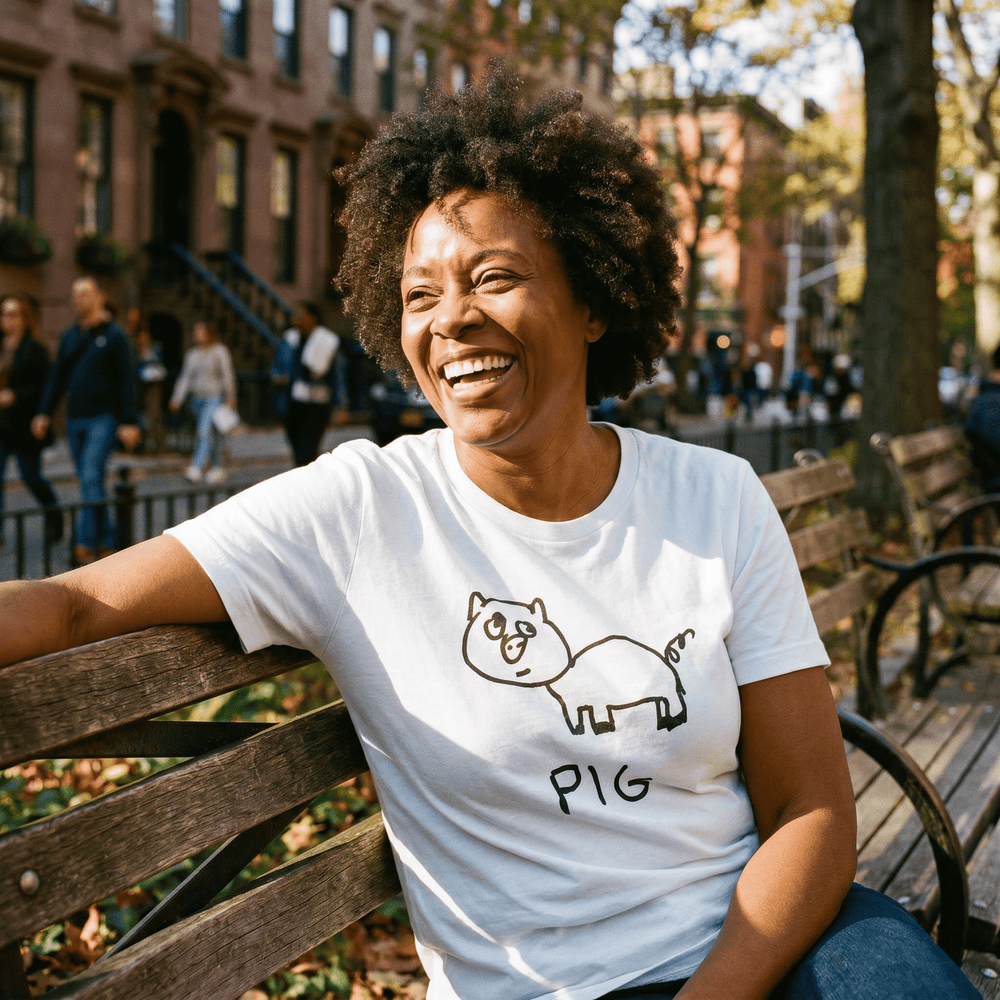 Woman seated on a park bench in a lo-fi Pig Women's Relaxed T-Shirt in white