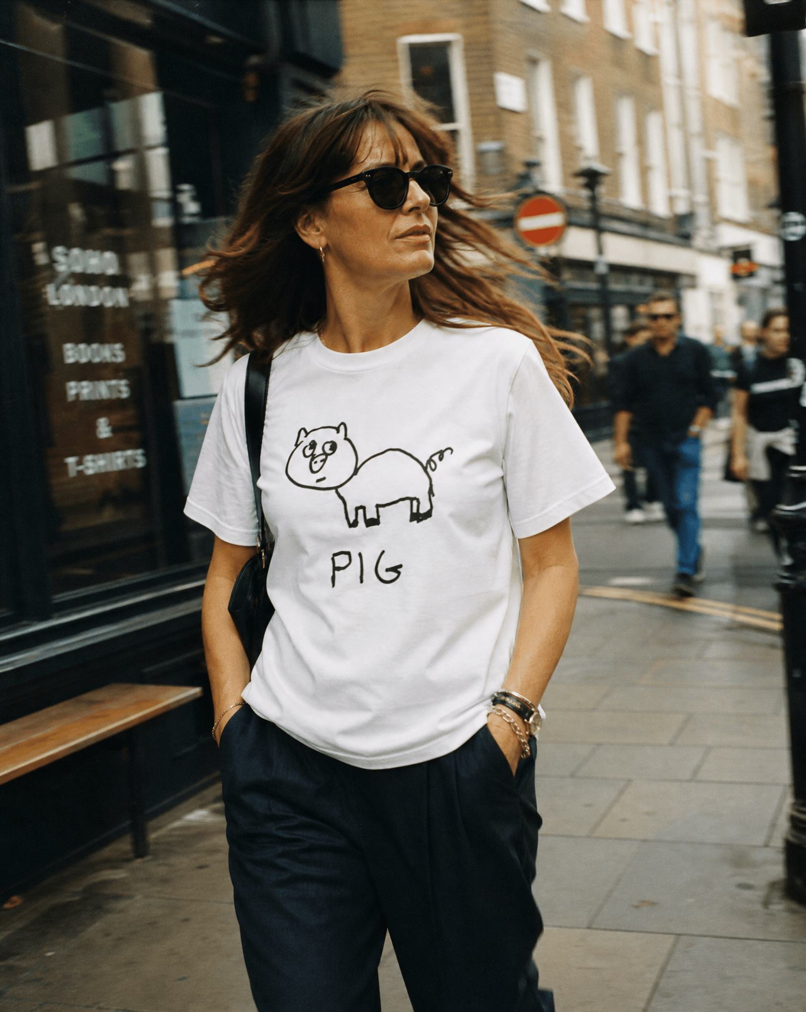 Woman walking a SoHo shopping street wearing a lo-fi Pig Women's Relaxed Fit T-Shirt in white