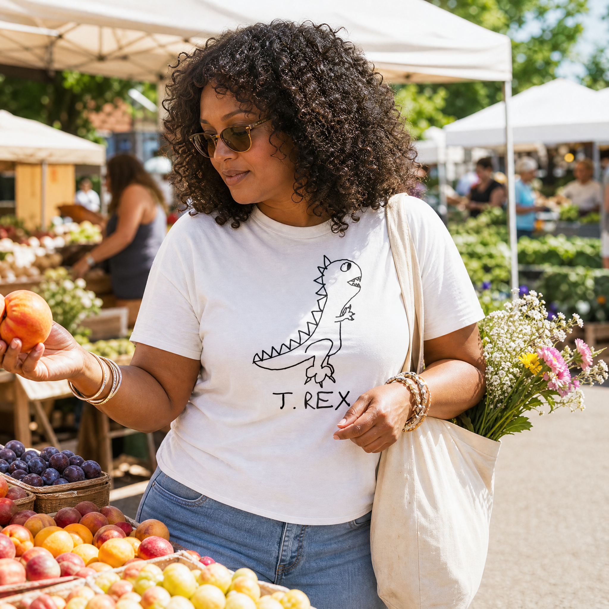Woman in sunglasses picking a peach at a farmers market wearing a lo-fi T. Rex Classic Tee