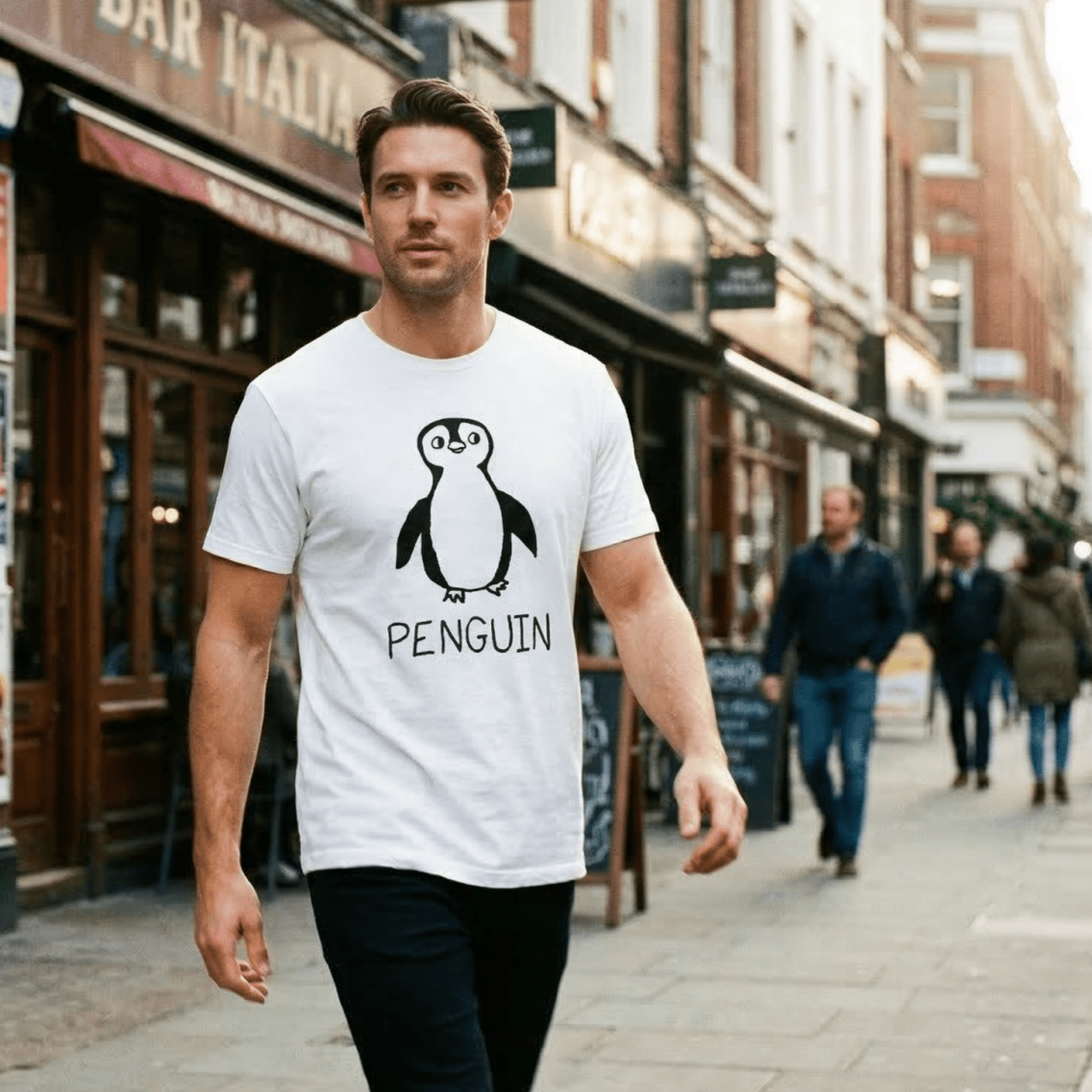 Man walking a European cobblestone street wearing a lo-fi Penguin Classic Tee in white