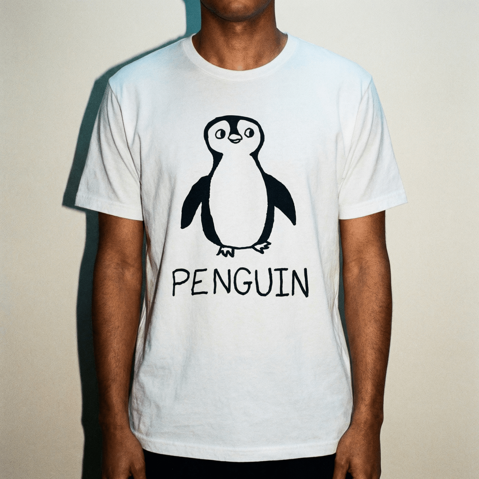 Man wearing a lo-fi Penguin Classic Tee in white against a neutral studio backdrop