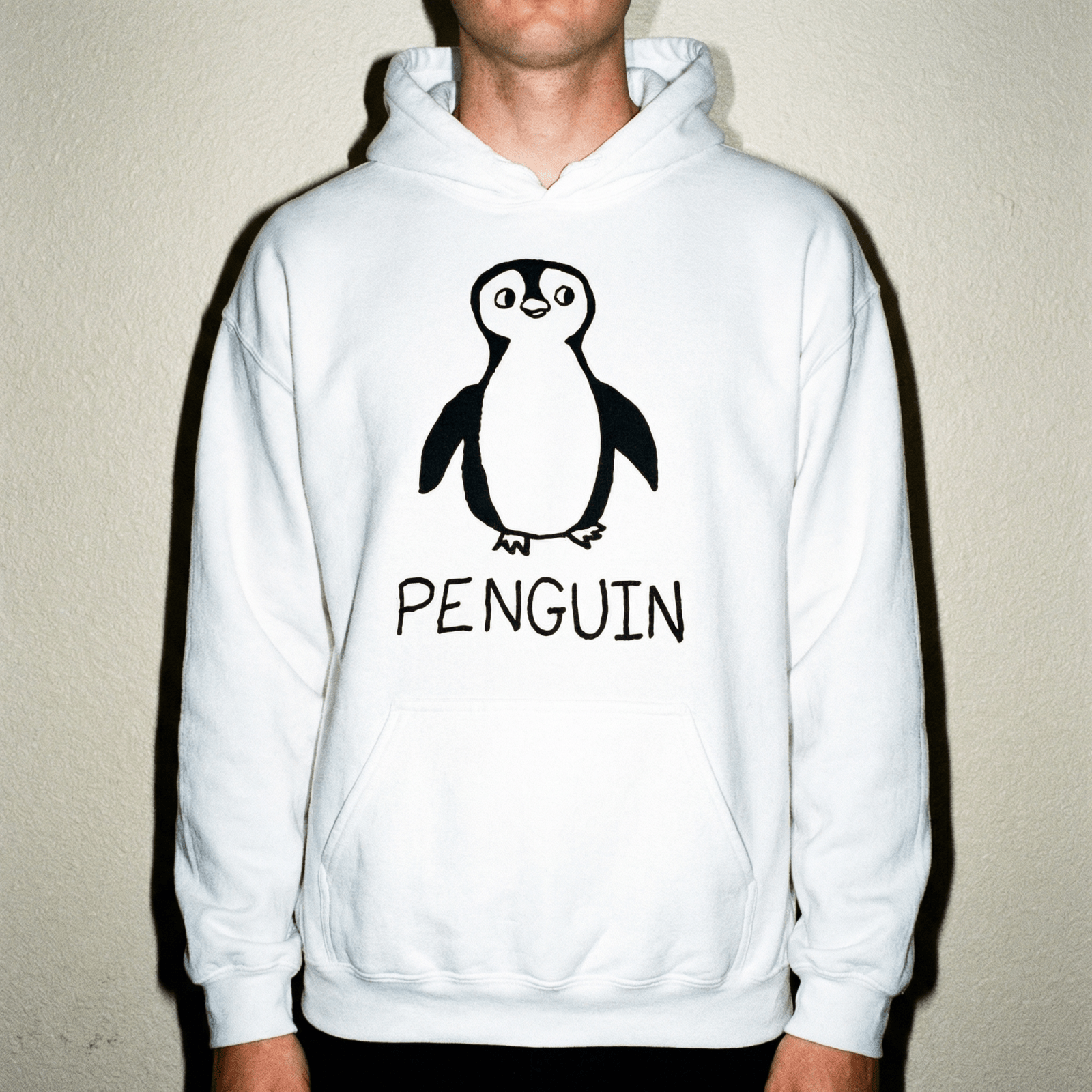 Man wearing a lo-fi Penguin Hoodie in white against a neutral studio backdrop