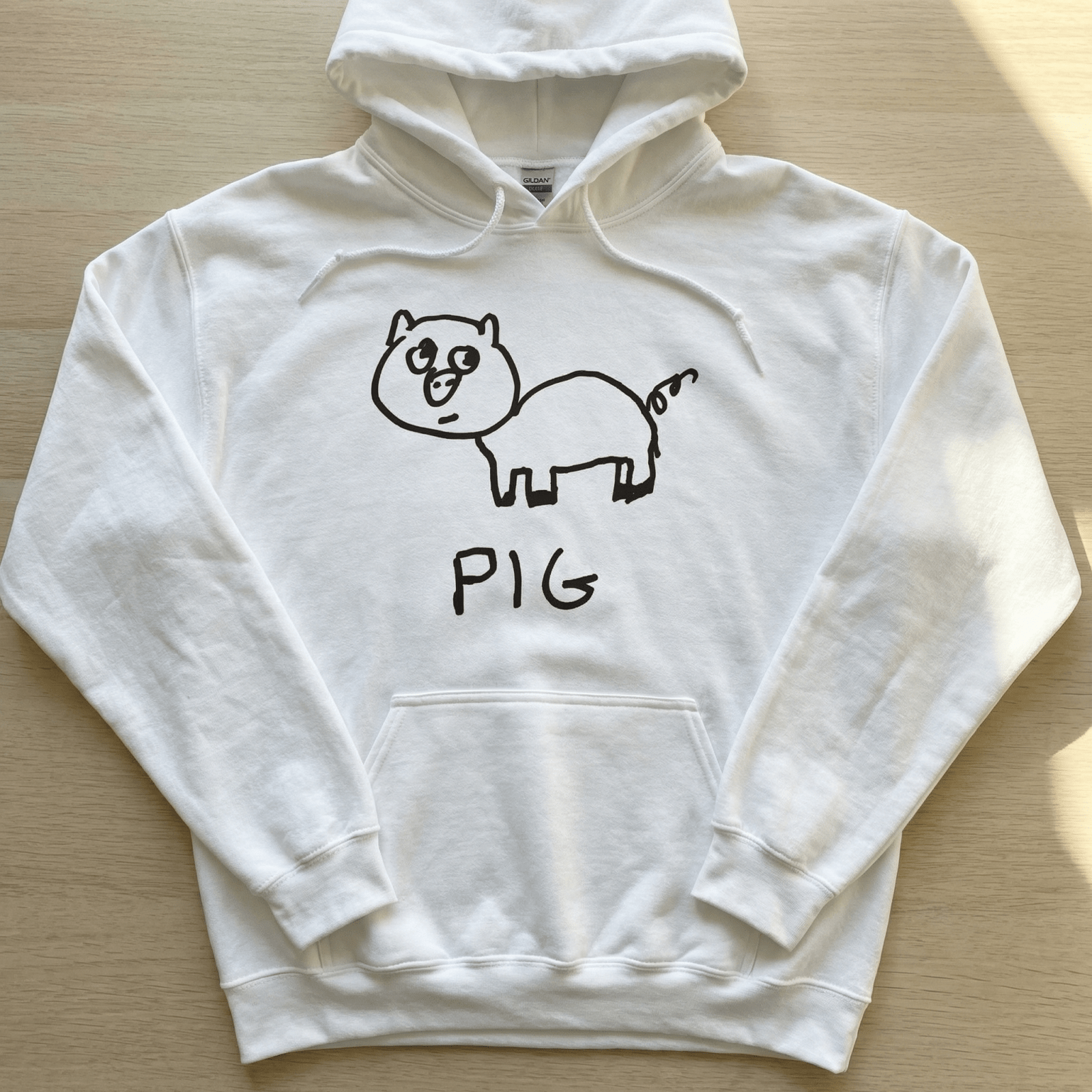 Flat lay of a lo-fi Pig Hoodie in white on a table