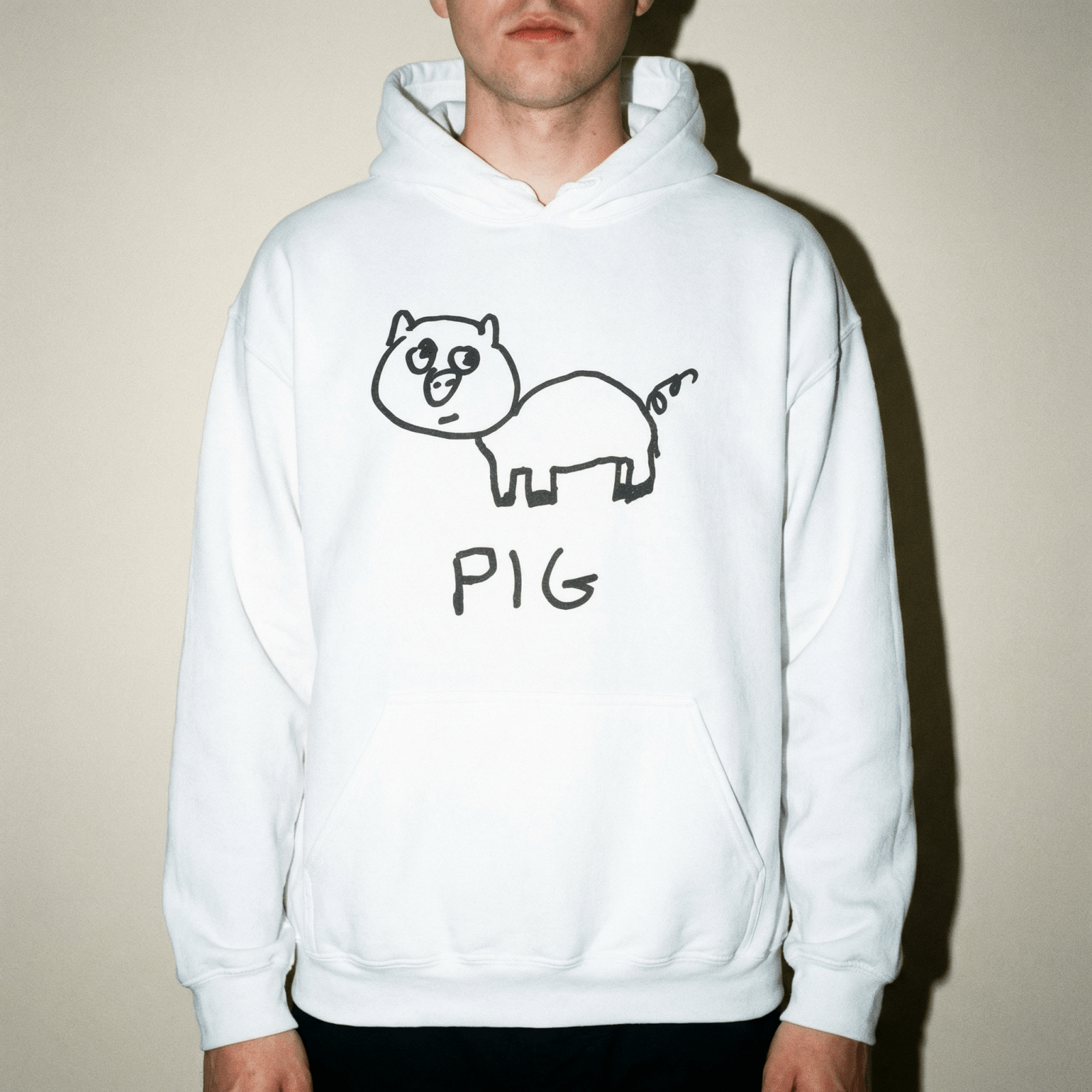 Man wearing a lo-fi Pig Hoodie in white against a neutral studio backdrop