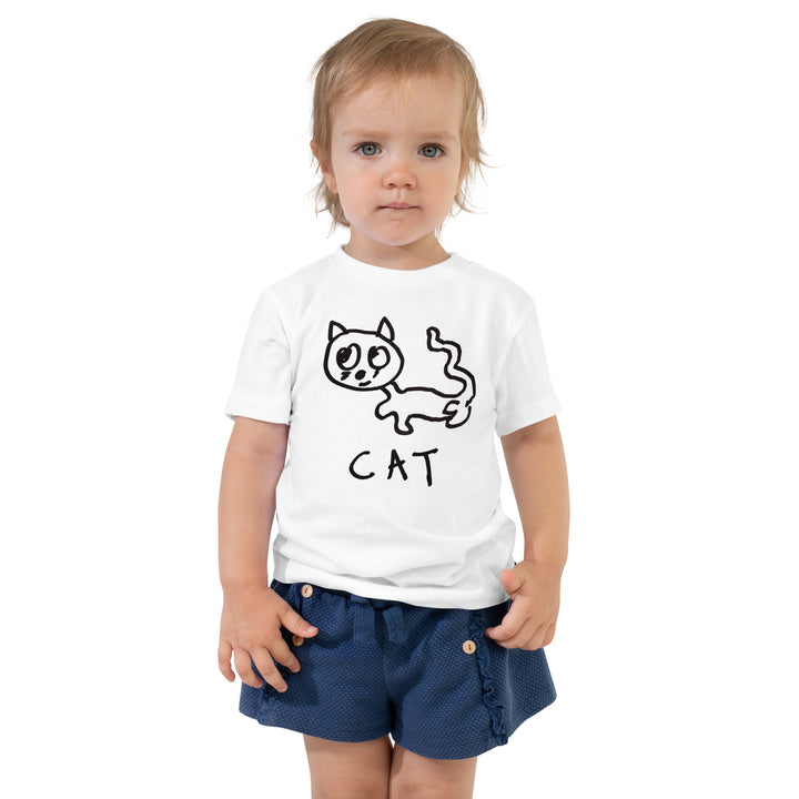 Toddler wearing a white t-shirt with a lo-fi hand-drawn cat graphic and text.