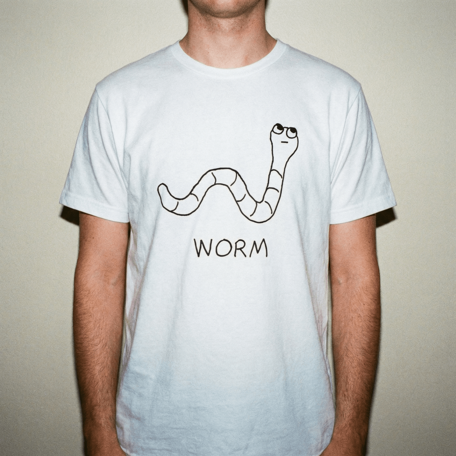 Studio torso view of a man wearing a lo-fi Worm Classic Tee